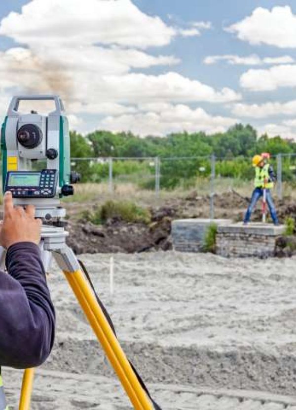 Geodesist is working with total station on a building site. Civi Ace Excavating Austin - Land Clearing, Grading & Site Prep